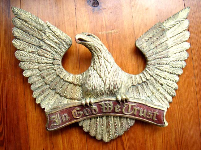 An early 20th century carved eagle plaque with the motto "In God We Trust."